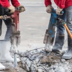 construction workers drilling into concrete