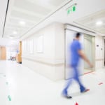 Bluured Doctor Walking Through Hospital Corridor