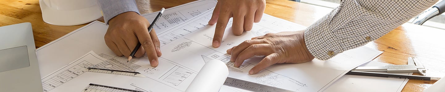 Hands of team working on architect drawings